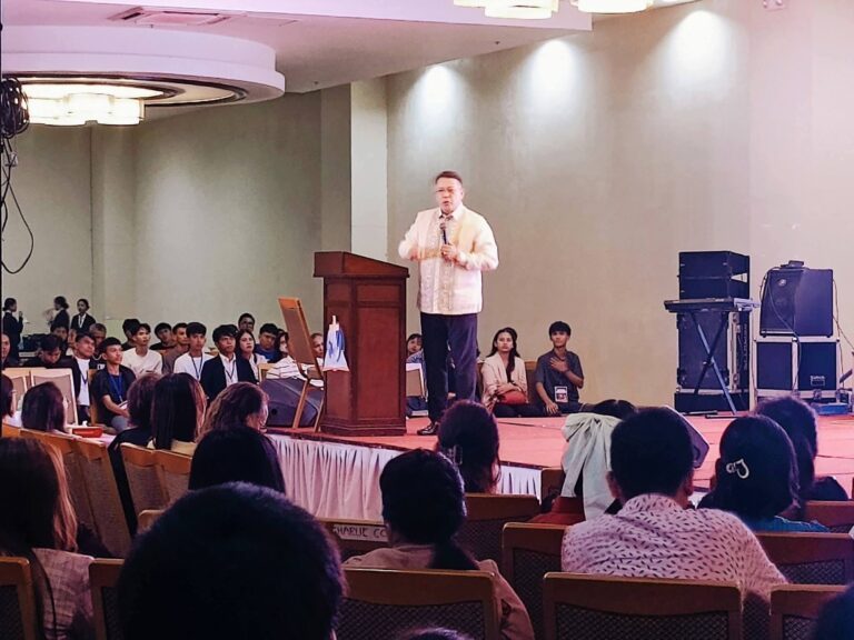 Bishop Rod Cubos speaking to a seated congregation in a hall
